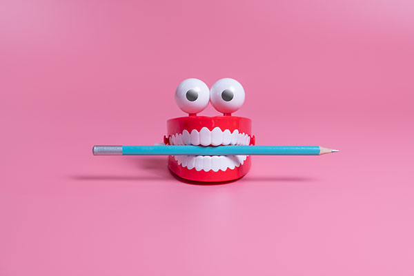 Joke teeth holding pencil - fun copywriting concept